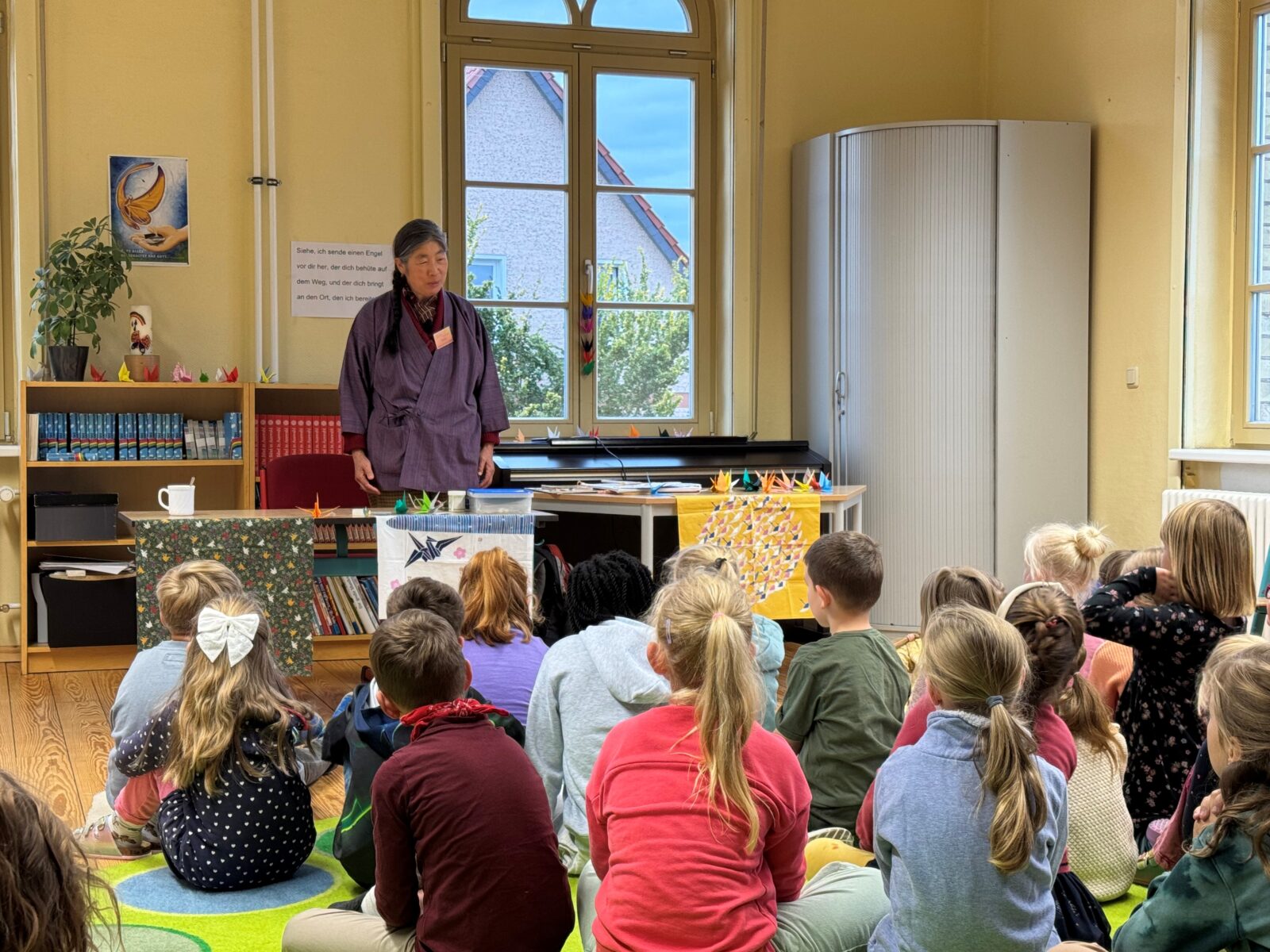 Frau Fabik erzählt den Kindern japanische Märchen über Kraniche.